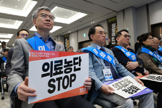 김택우 대한의사협회 회장이 13일 서울 용산구 의협회관에서 열린 전국의사대표자대회에 참석해 손팻말을 들고 있다. <사진: 연합뉴스>